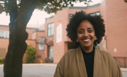 a smiling woman with curly black hair
