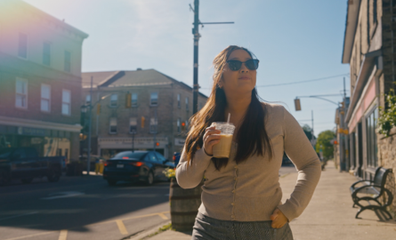 a woman walks down a street in a small town