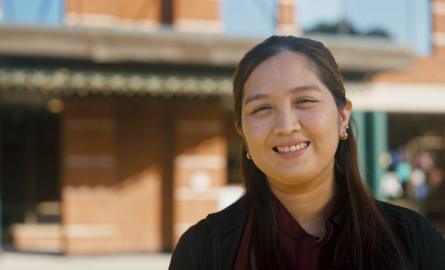 a smiliing woman looks confidently at the camera