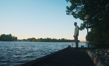 a man looks over the waters of a lake
