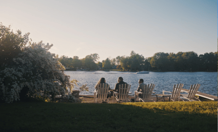 a family sits by the water