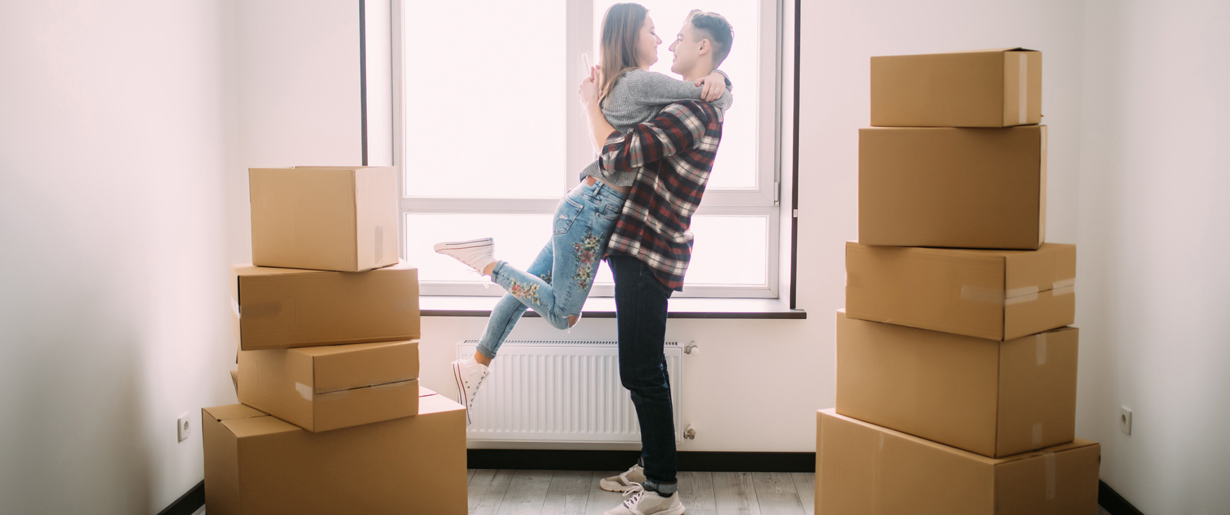 People with boxes moving into a home