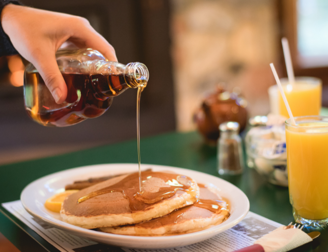 maple syrup pouring over pancakes