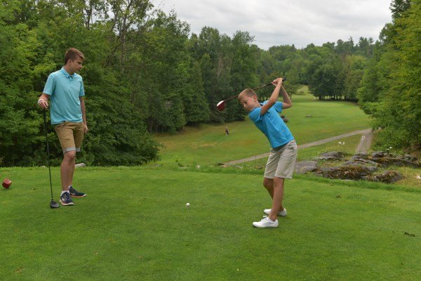 two boys play golf