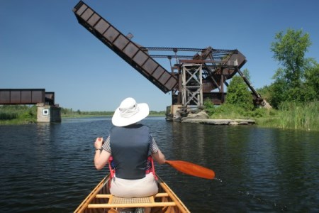a person paddling near a bridge