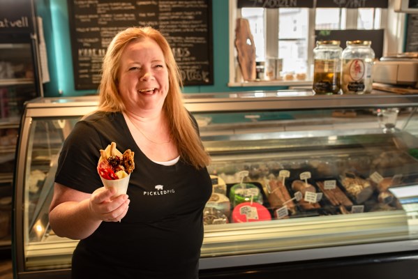 a woman smiling and holding a crepe