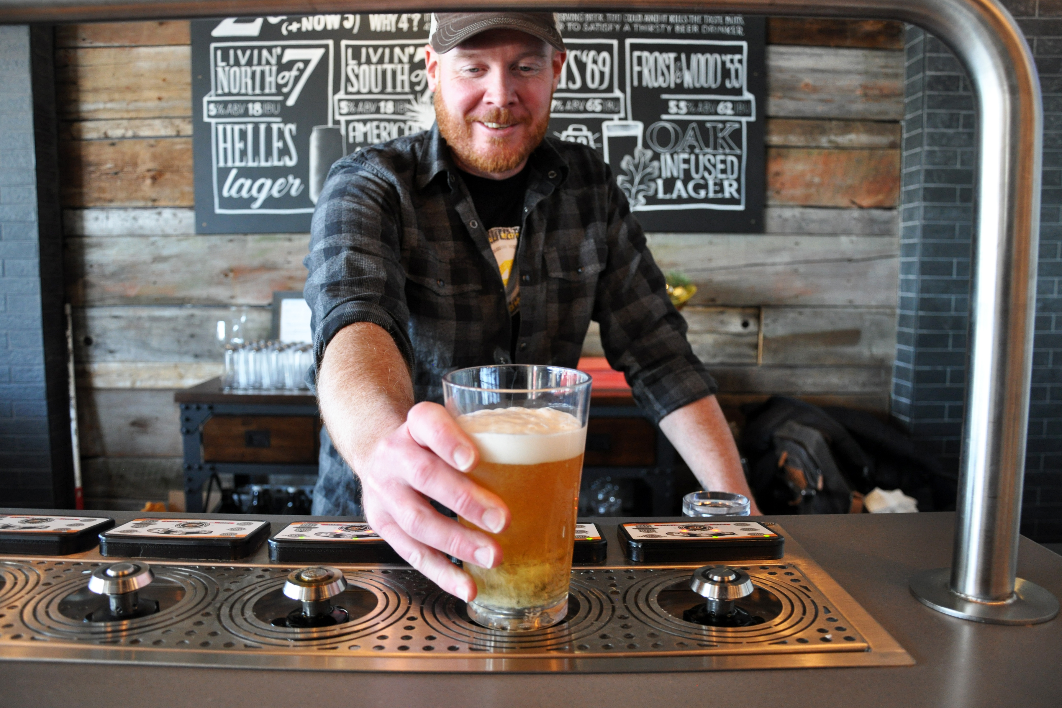 Man holding out a glass of beer.