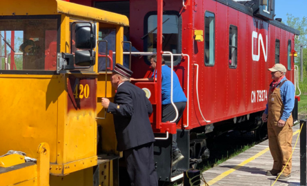 a man dressed as a conductor standing by a train