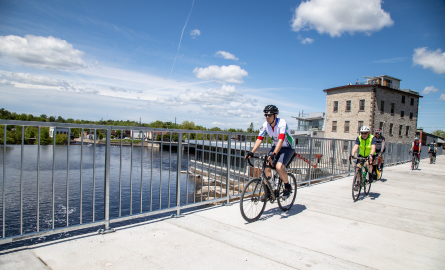 cyclists ride across a bridge