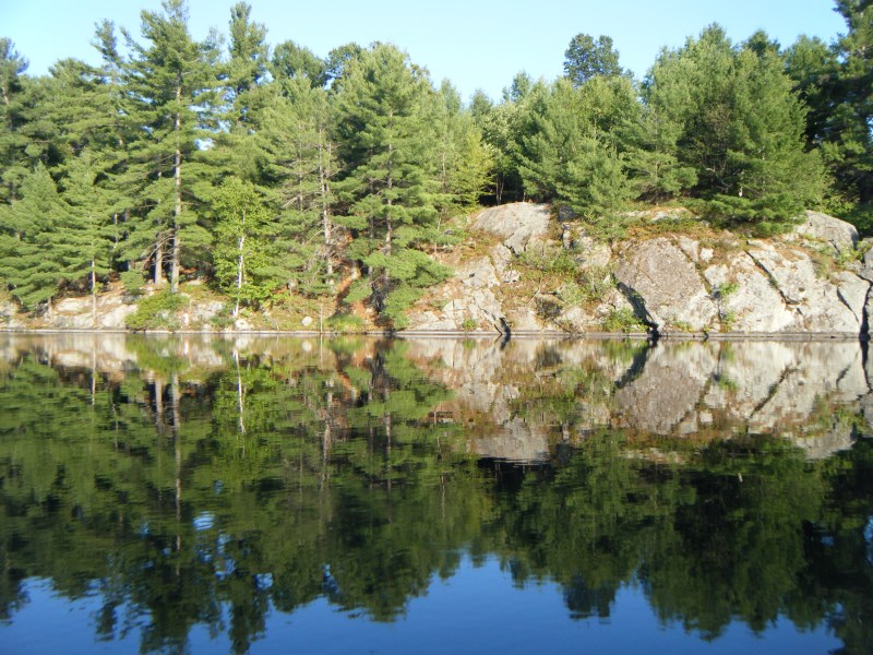 a lake clearly reflects the blue sky