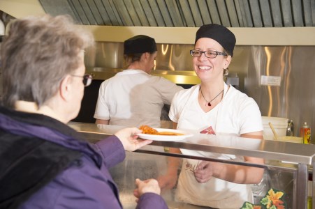 a customer gets food from a servicer in a restaurant