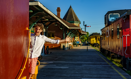 a young man stretches out his hand to catch a train