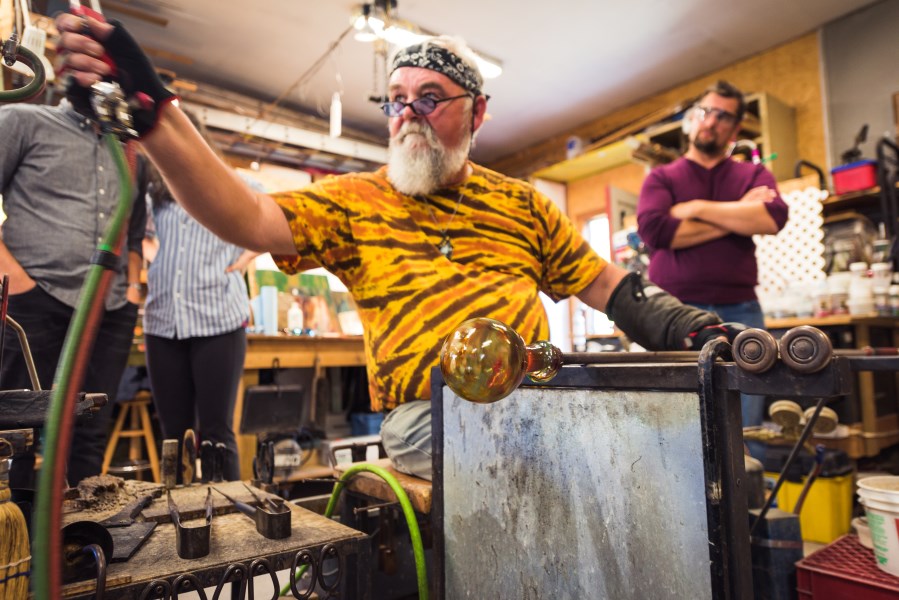 a glass artist blowing glass