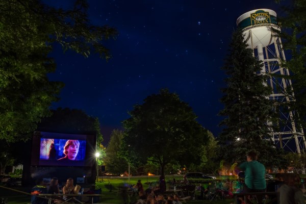 People watching movies under sky at night