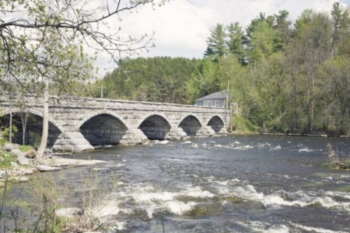 Scenic view of the picturesque Five Span Bridge showcasing a beautiful river, lush trees, and the architectural marvel of the bridge's five spans