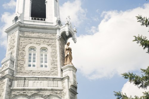 Exterior view of St. Peter Celestine Church, adorned with a captivating sculpture, ornate walls, and elegant windows against a backdrop of blue sky