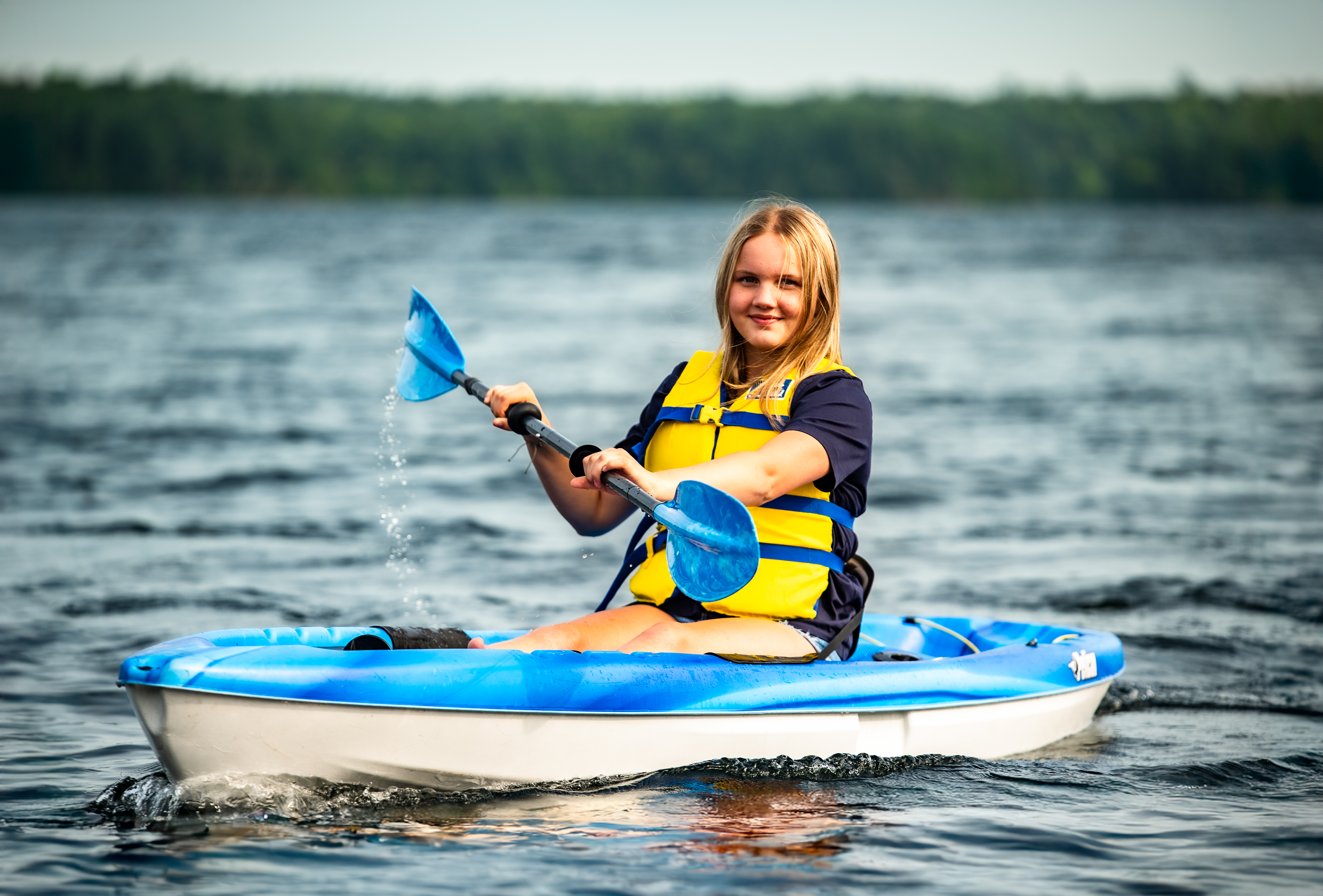 Child paddling in kayak.