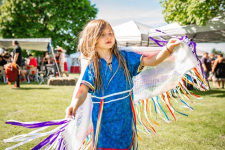 a girl wearing first nation custom dances