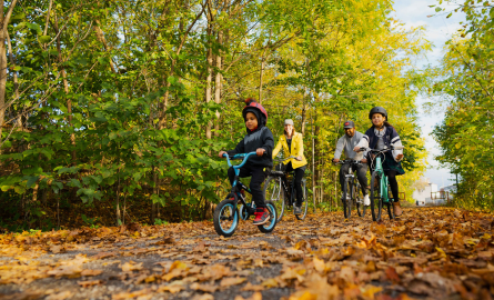 a family riding bikes along a trail in the fall