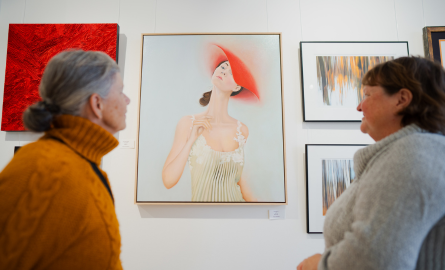 two women look at a painting