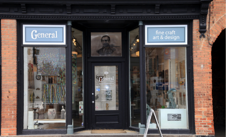 a shop front with art works displayed in the windows