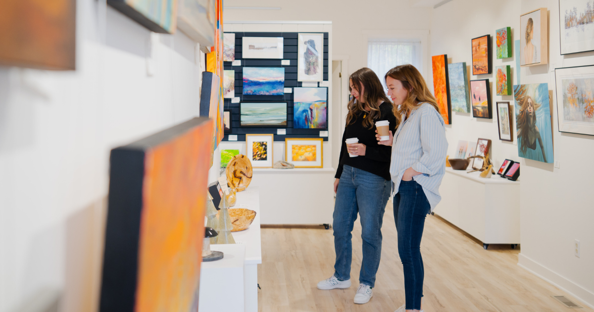 two women looking at paintings