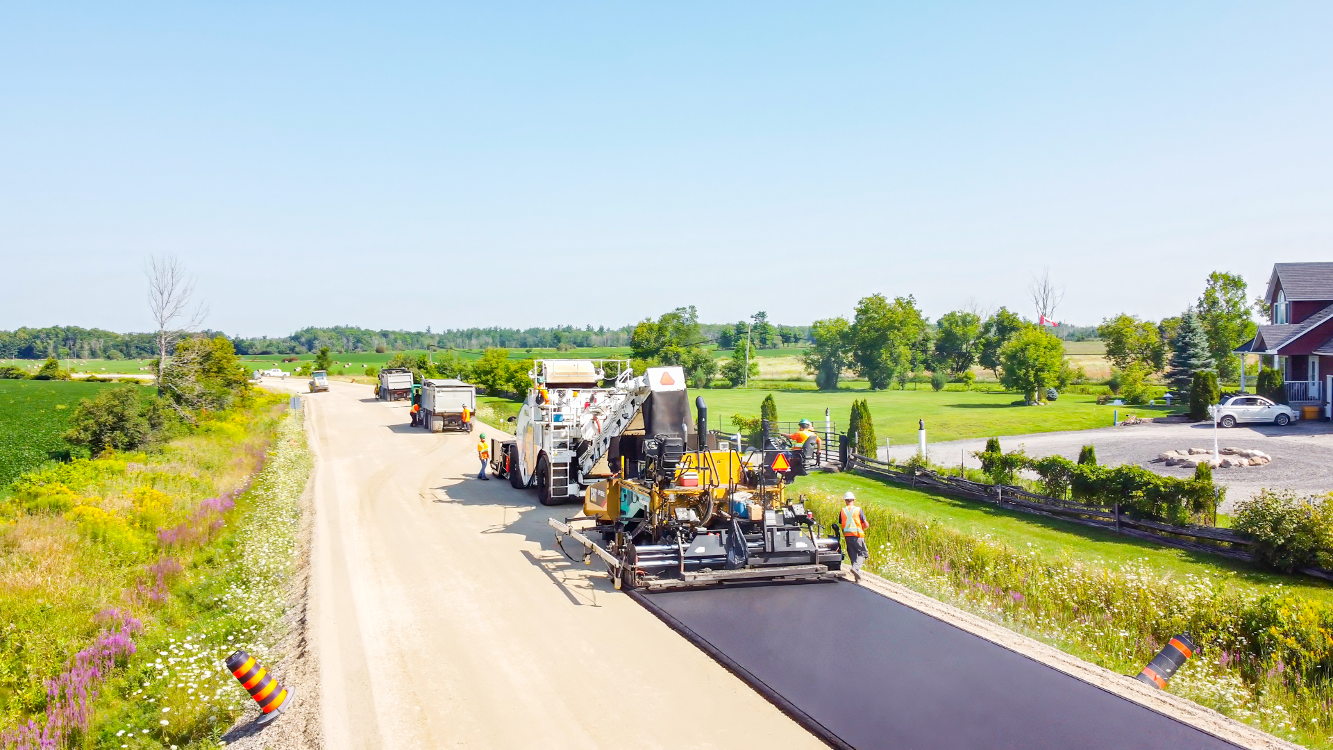 Road construction crew paving a rural road