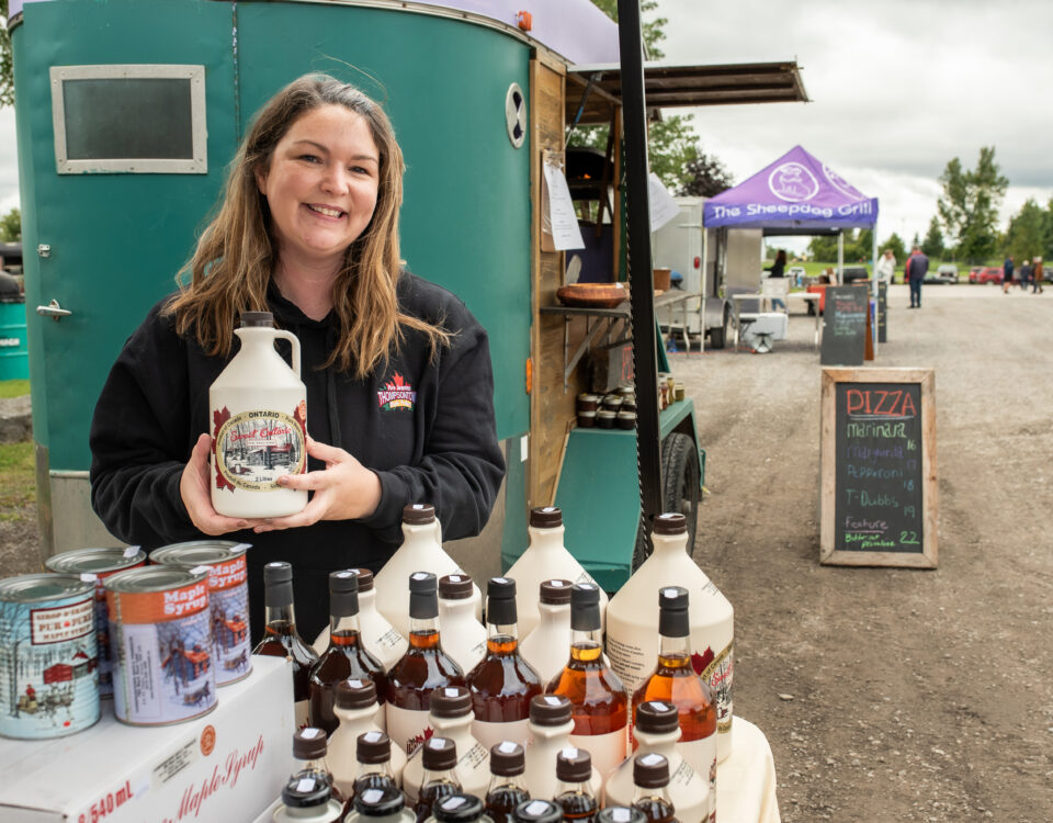 Person showcasing maple syrup.