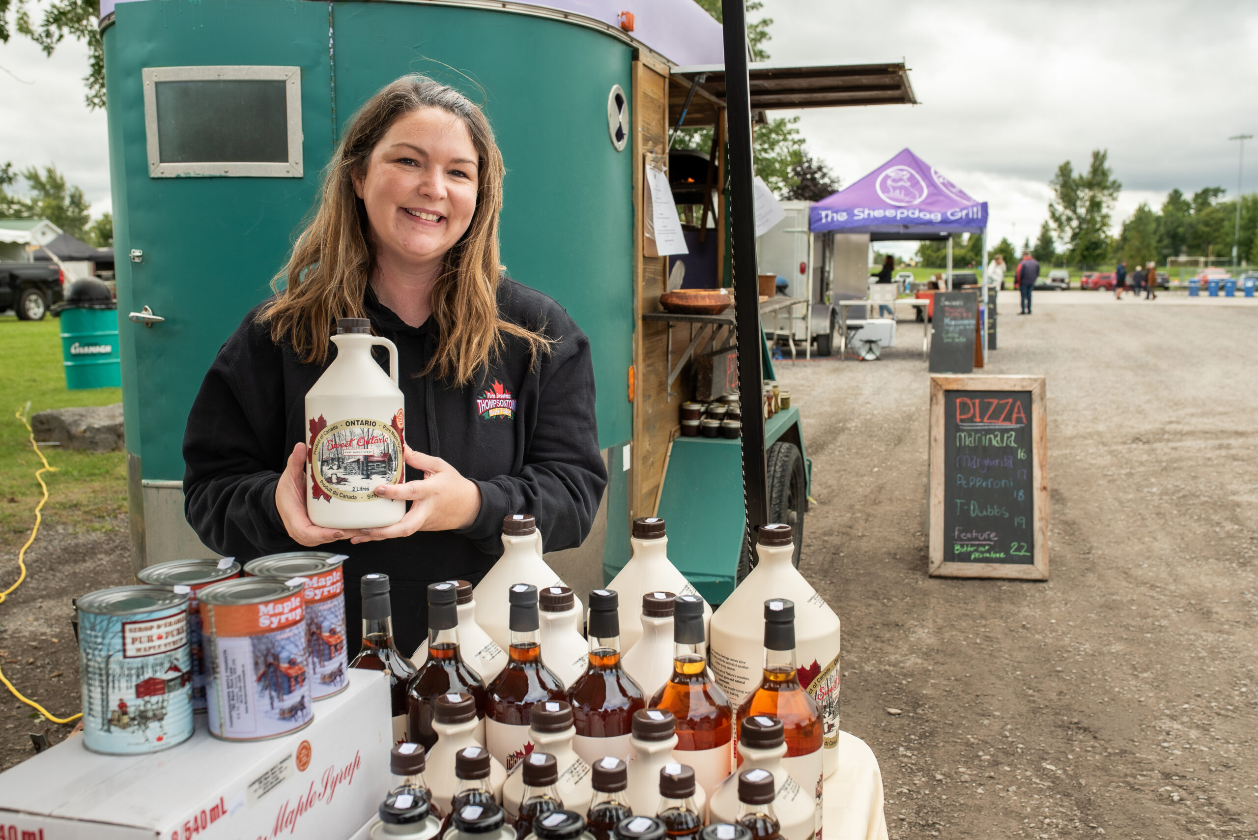 Person showcasing maple syrup.